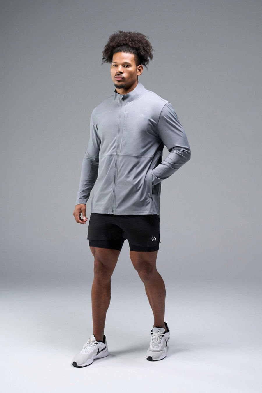 Front View of Gray TLF Element Athletic Jacket, featuring multiple zipper pockets, and ripstop panels for breathability and stretch