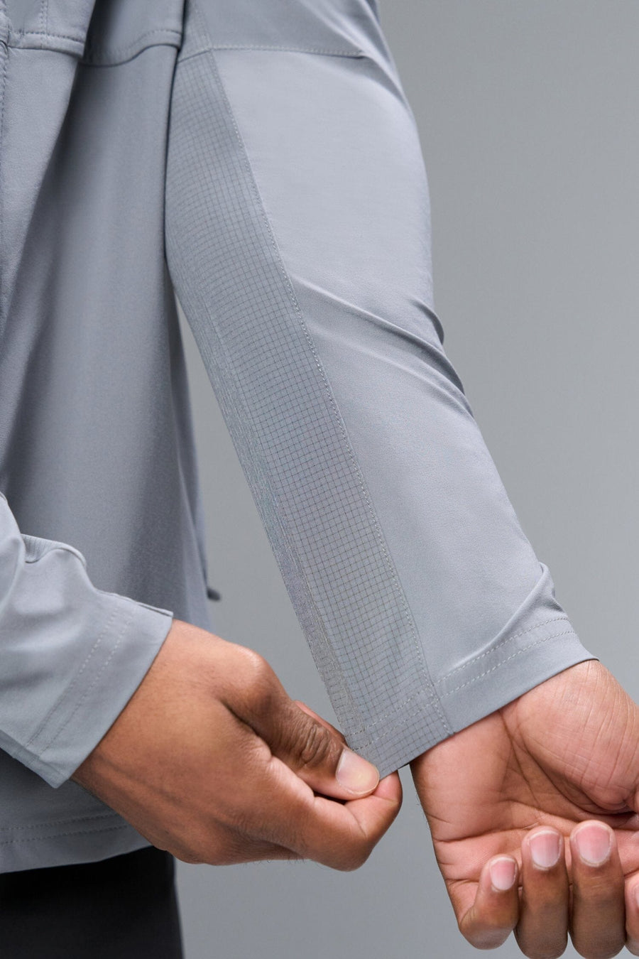 Detail Sleeve View of Gray TLF Element Athletic Jacket, featuring multiple zipper pockets, and ripstop panels for breathability and stretch