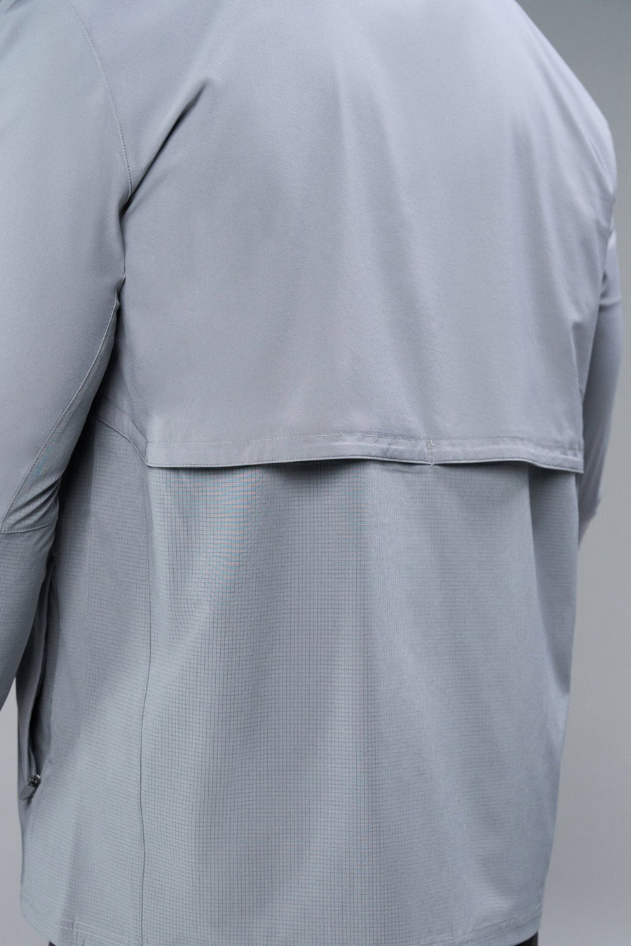 Back View of Gray TLF Element Athletic Jacket, featuring multiple zipper pockets, and ripstop panels for breathability and stretch