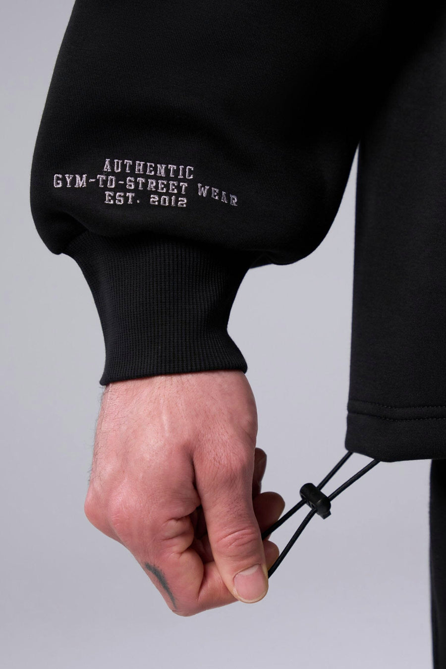Detail Right Sleeve View of Black TLF GTS Scuba Tech Quarter-Zip Pullover, featuring a ¼ zip pullover, sleek design and kangaroo pockets