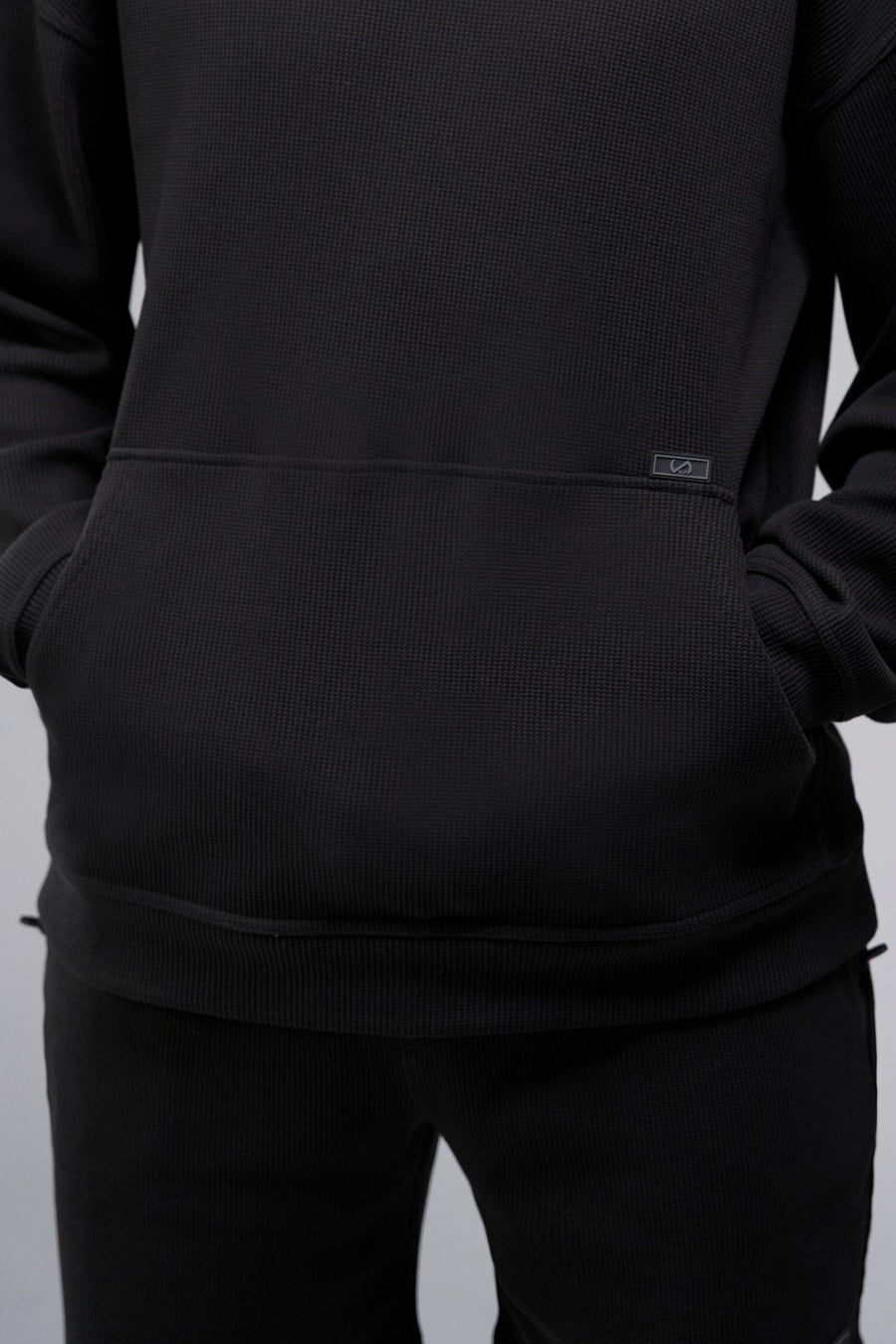 Detail Front View of Black TLF GTS Waffle Tech Hoodie, featuring kangaroo pockets, and double panel hoodie designed for all day wear