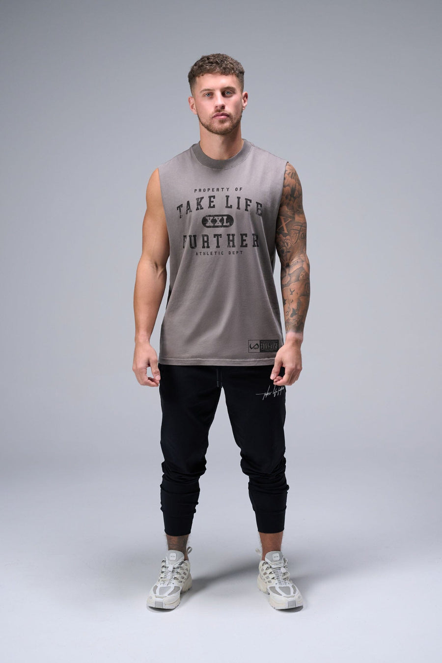 Front View of Gray TLF Property Of Heavy Cotton Muscle Tank featuring a distressed graphic design and raw edge arm holes.