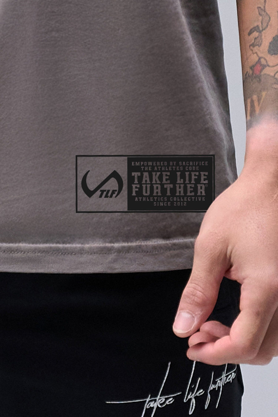 Detail Front View of Gray TLF Property Of Heavy Cotton Muscle Tank featuring a distressed graphic design and raw edge arm holes.