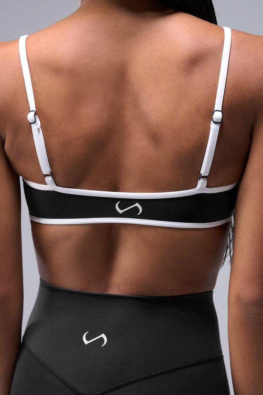 Back View of Black Tempo Minimal Bralette 2.0, featuring removable pads and adjustable straps for low impact all day wear