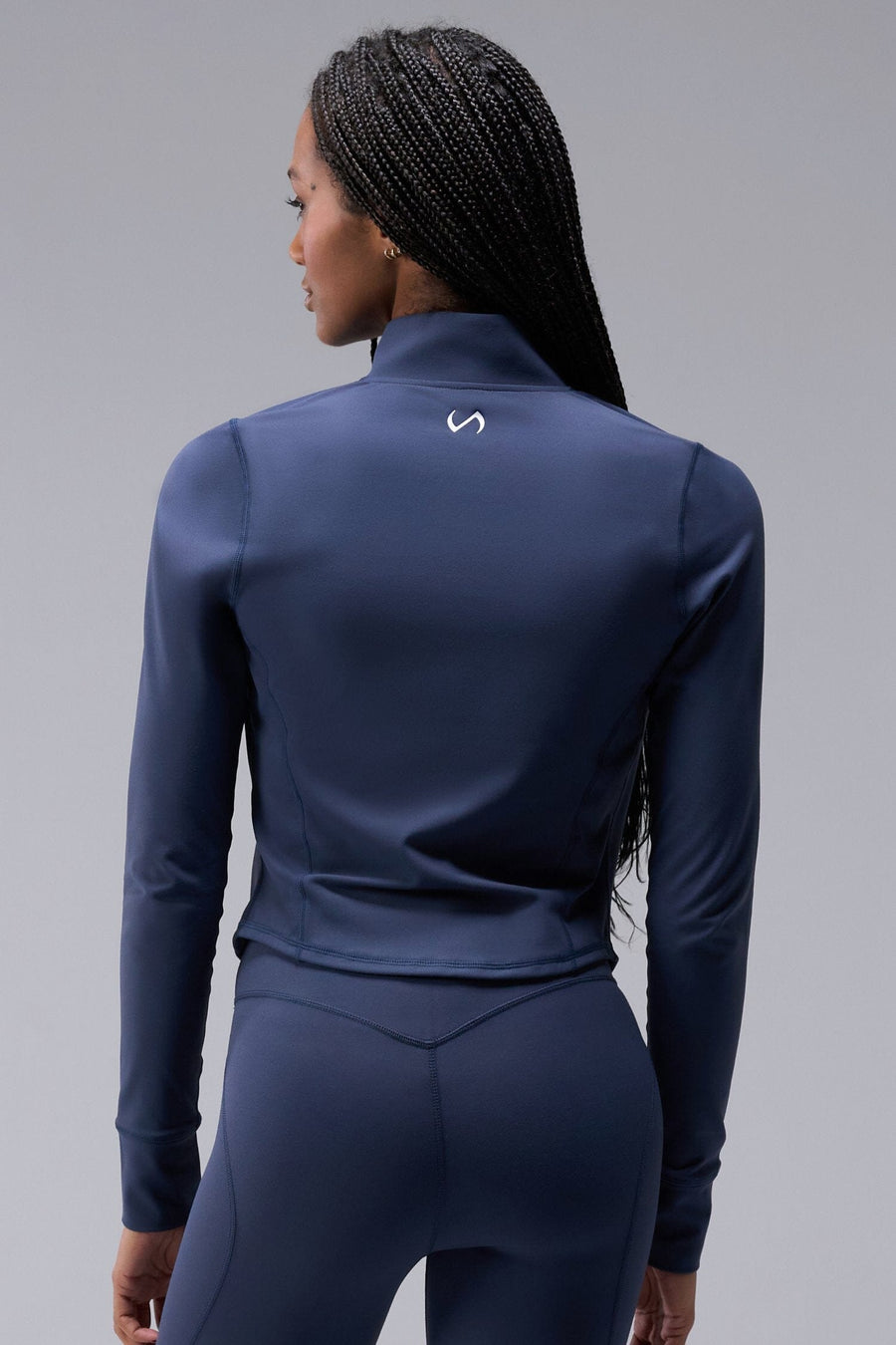 Back View of Blue TLF Tempo Cropped Zip Up Jacket featuring thumbholes and cropped length for gym and lifestyle wear