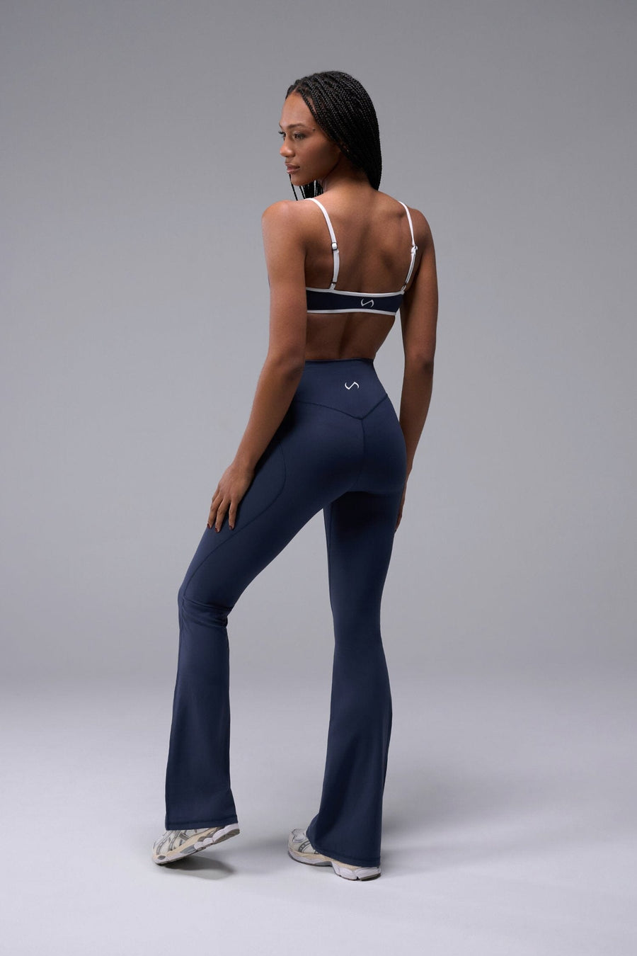 Back View of Blue TLF Tempo Flare Leggings, featuring a waist snatching crossover waistband and glute shaping side seam