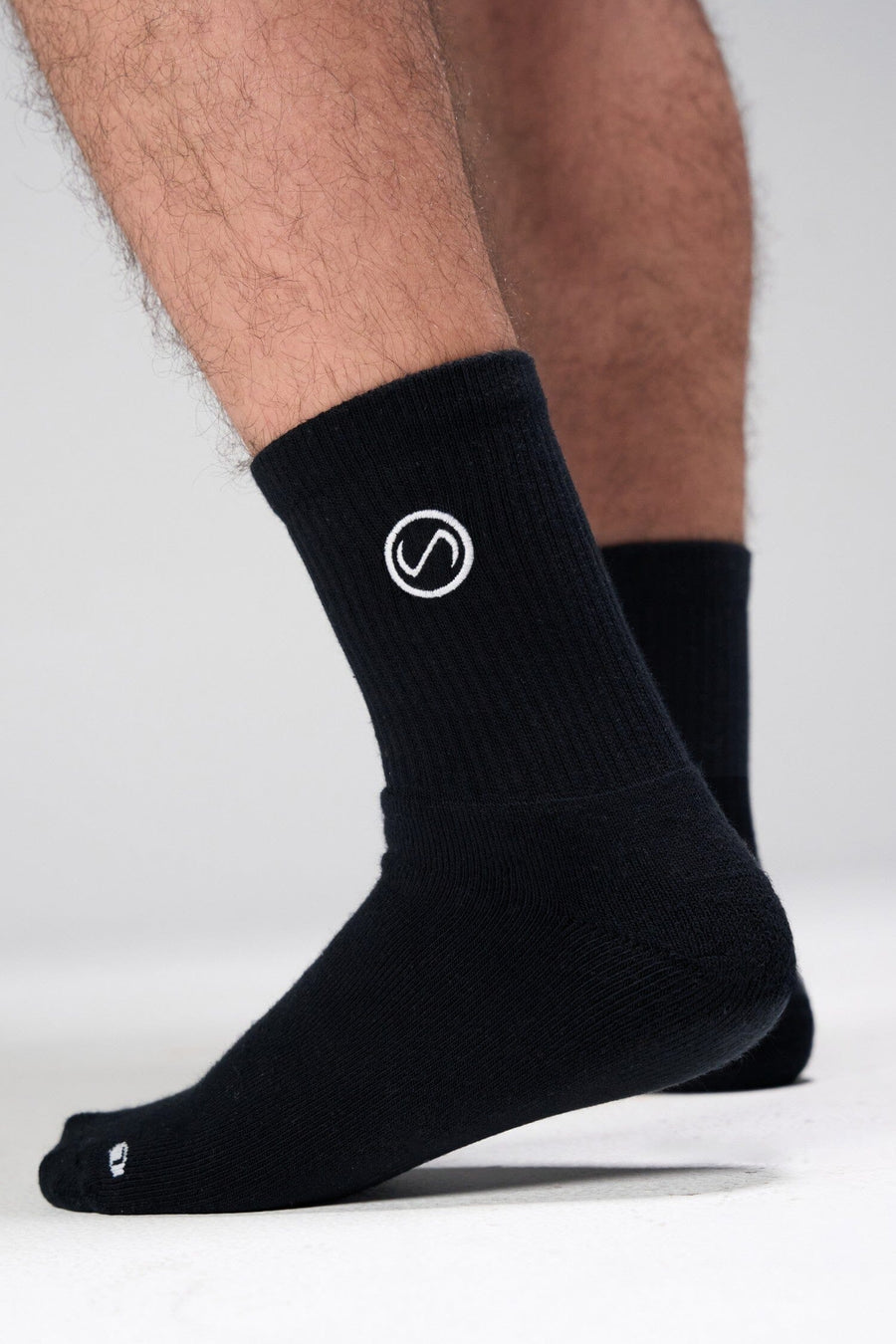 Side View of Black the TLF Evolve Half Crew Socks featuring an embroidered TLF logo and interiors take life further stitched detailing with a cushioned footbed