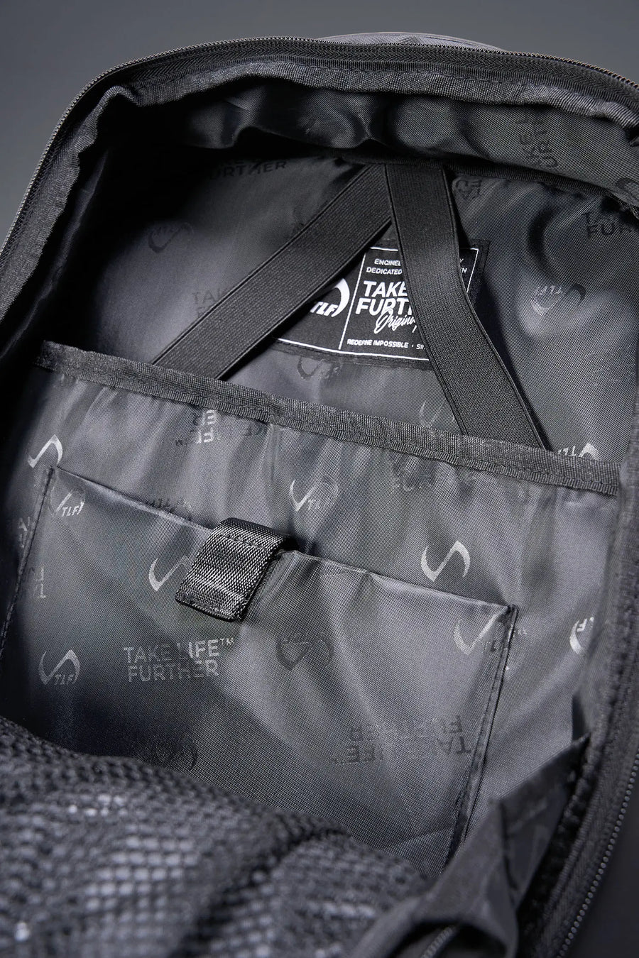 Black Apex Backpack with custom TLF PVC patch and durable matte finish detailing by TLF Apparel – detail view 