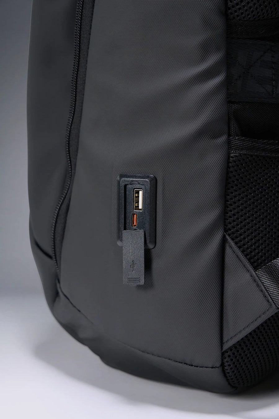 Black Apex Backpack with integrated luggage strap and hidden back zipper pockets for secure storage by TLF Apparel – side view
