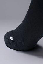 Side View of Black the TLF Evolve Crew Socks featuring an extended cuff height, ribbed cuff, cushioned footbed and seamless toe