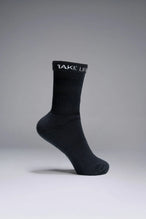 Side View of Black the TLF Evolve Half Crew Socks featuring an extended cuff height, ribbed cuff, cushioned footbed and seamless toe