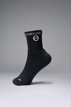 Side View of Black the TLF Evolve Half Crew Socks featuring an extended cuff height, ribbed cuff, cushioned footbed and seamless toe