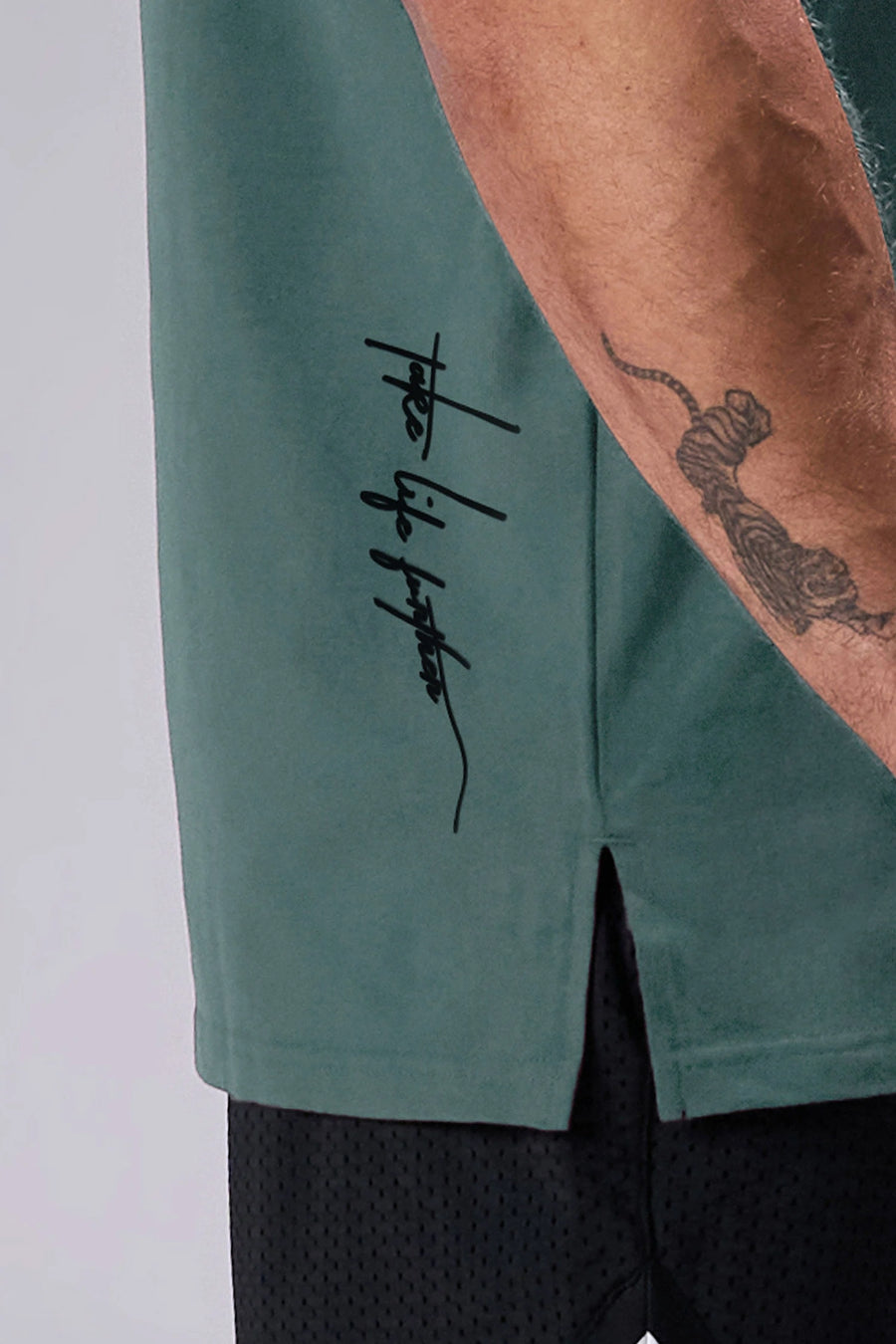 Green Classic Script Cotton Luxe Oversized Tee showing left neck icon logo, woven hem clip label, and Cotton Luxe DNA fabric by TLF Apparel – detail view 