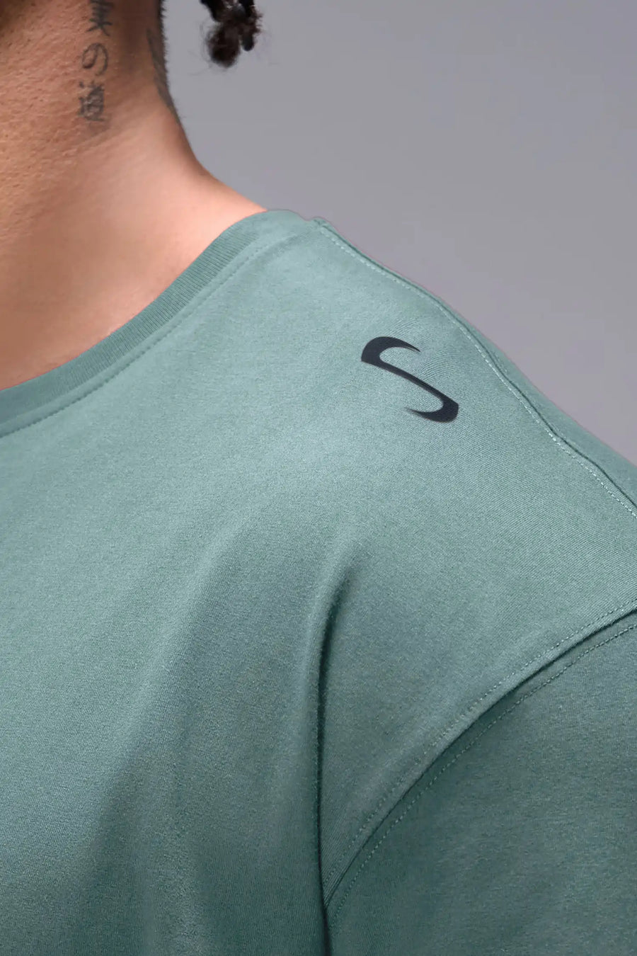Green Classic Script Cotton Luxe Oversized Tee showing left neck icon logo, woven hem clip label, and Cotton Luxe DNA fabric by TLF Apparel – detail view 