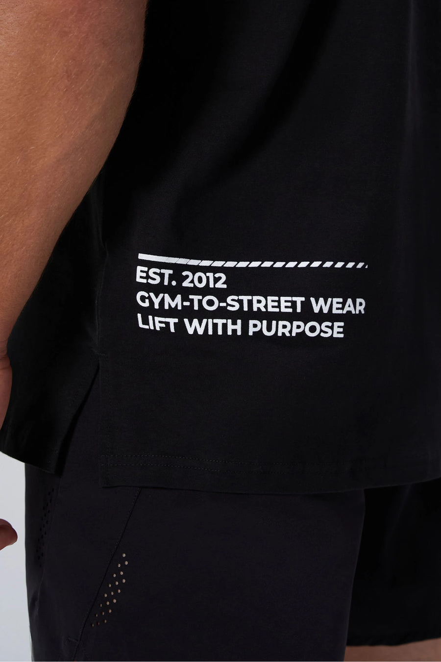 Black Take Life Further Oversized Tee showing side split hem, woven hem clip label, and Cotton Luxe DNA fabric by TLF Apparel – detail view 