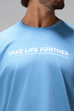 Blue Take Life Further Oversized Tee showing side split hem, woven hem clip label, and Cotton Luxe DNA fabric by TLF Apparel – detail view