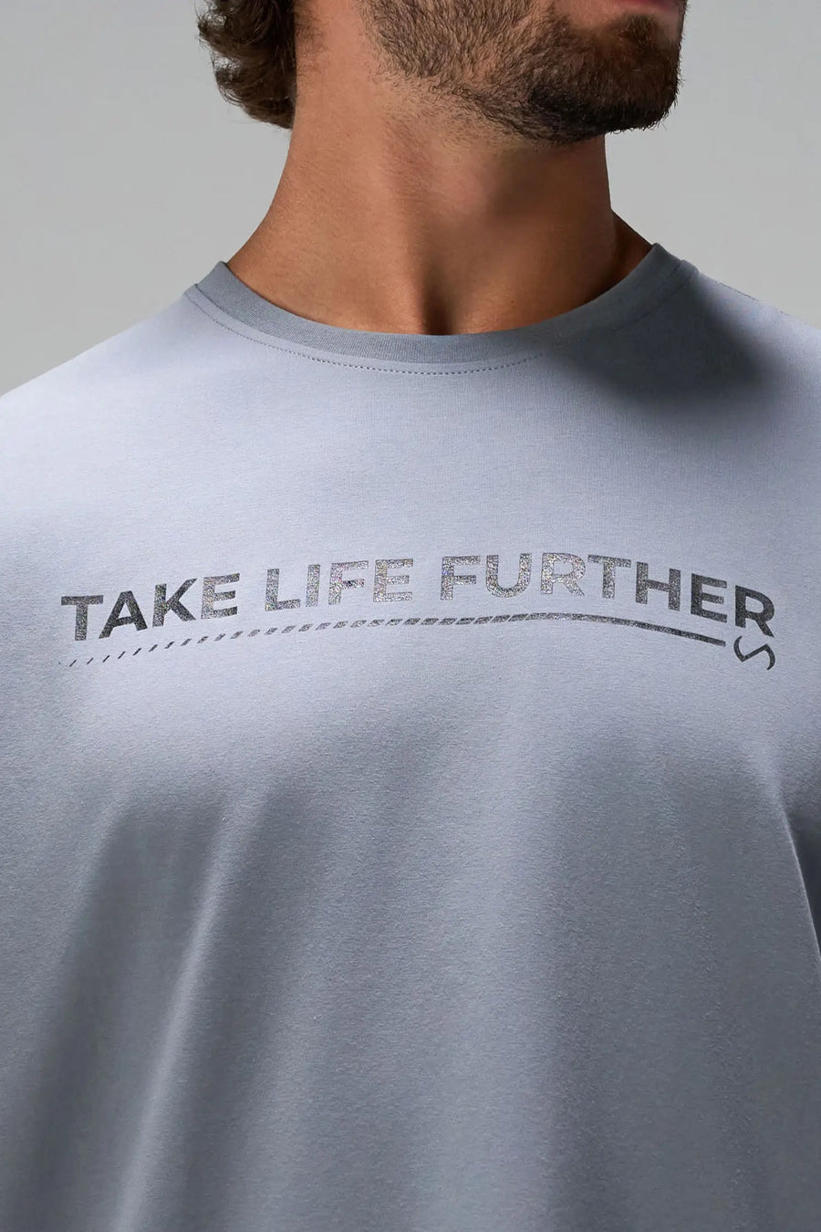 Gray Take Life Further Oversized Tee showing side split hem, woven hem clip label, and Cotton Luxe DNA fabric by TLF Apparel – detail view