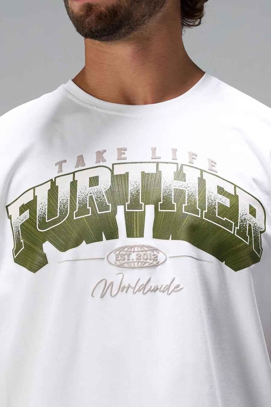 White Take Life Further Oversized Tee showing distressed varsity chest print, EST 2012 globe crest, and Cotton Luxe DNA fabric by TLF Apparel – detail view