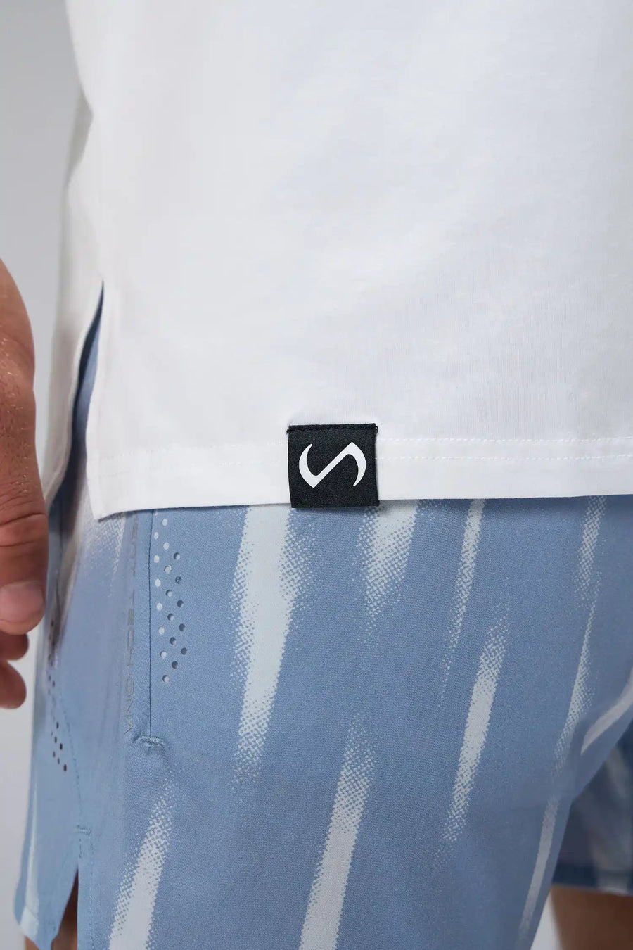 White Statement Cotton Luxe Oversized Tee showing side split hem, woven hem clip label, and Cotton Luxe DNA fabric by TLF Apparel – detail view 