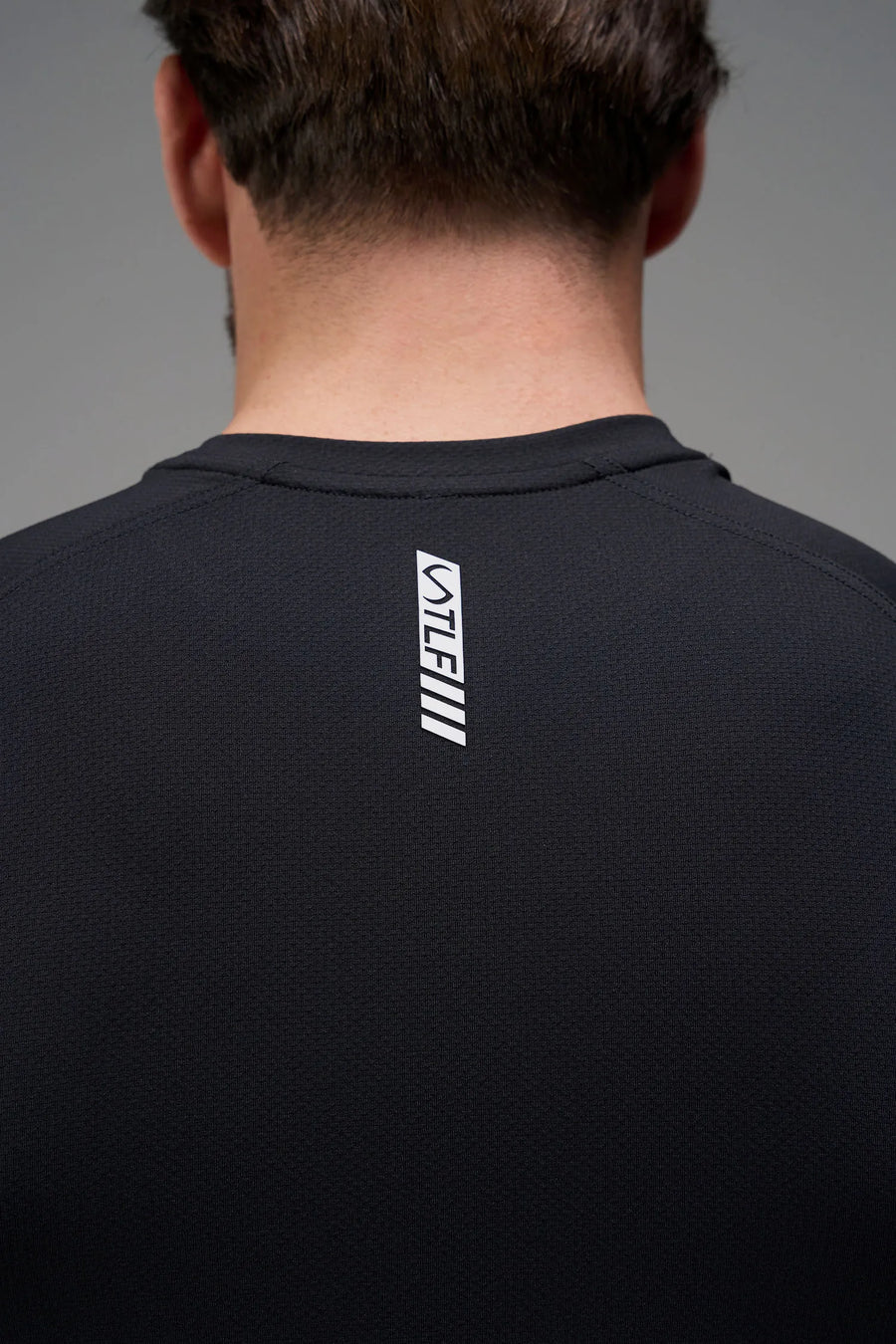 Black Men’s Micro Mesh Tee with a physique-enhancing fit, designed for gym training, HIIT workouts and running by TLF Apparel – back view 