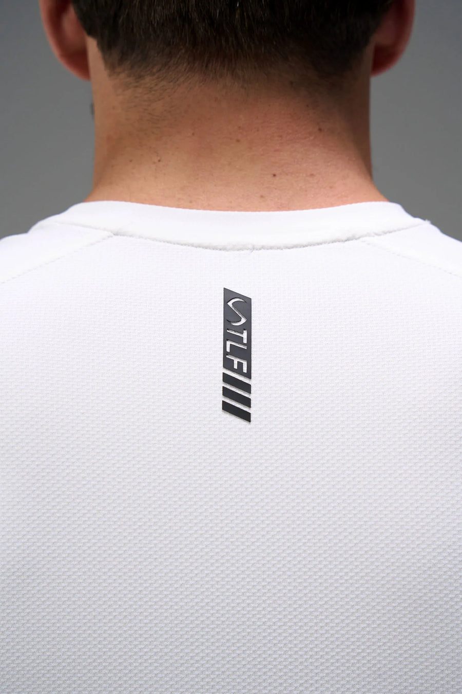 White Men’s Micro Mesh Tee with a physique-enhancing fit, designed for gym training, HIIT workouts and running by TLF Apparel – back view 