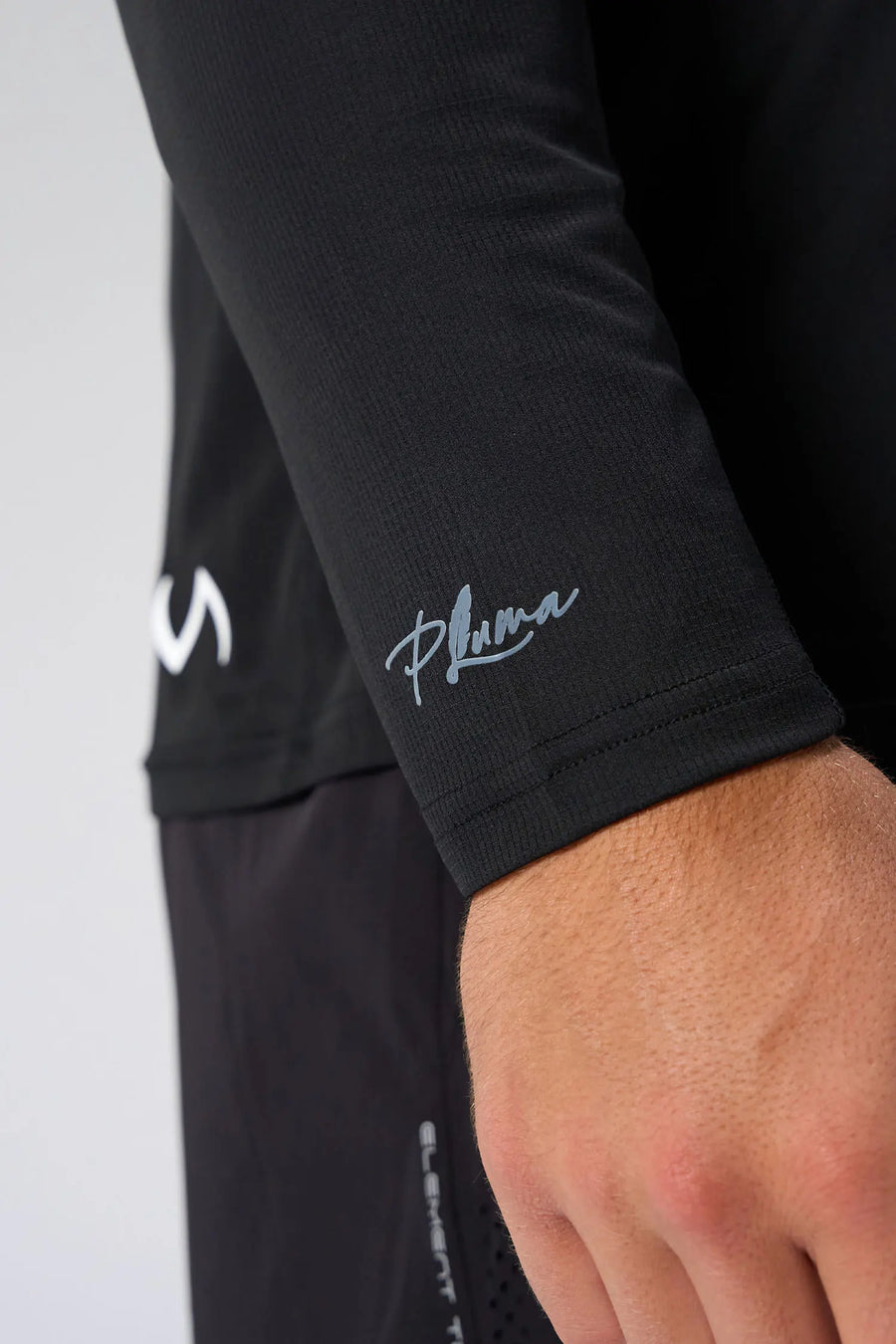 Black Pluma UPF Sun Hoodie showing UV color-changing wrist logo and micro-grid knit fabric by TLF Apparel – detail view