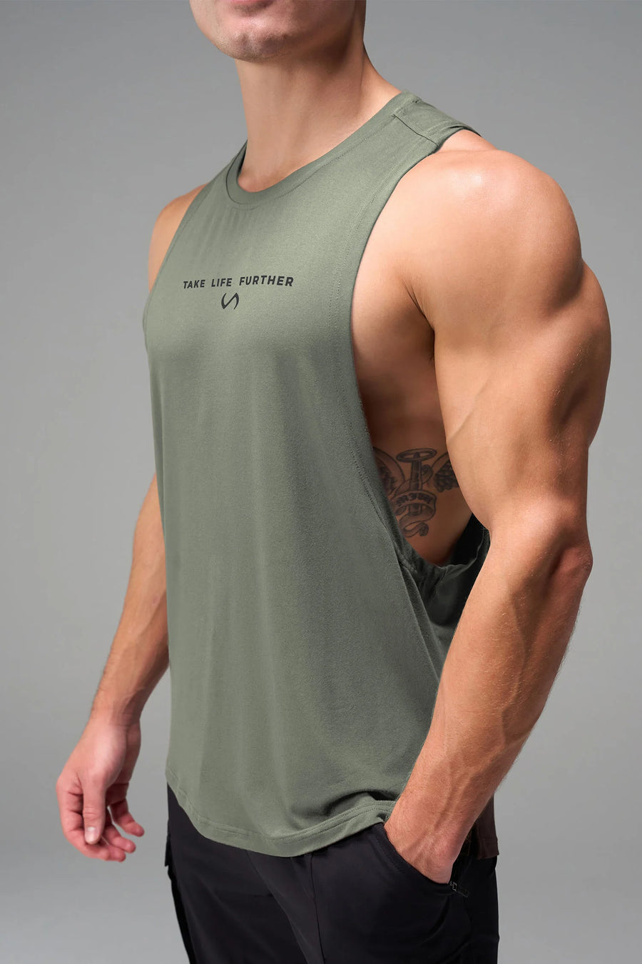 Green Further Air-Flex Drop Arm Tank showing ultra-soft performance fabric and Take Life Further® chest logo detail by TLF Apparel – detail view