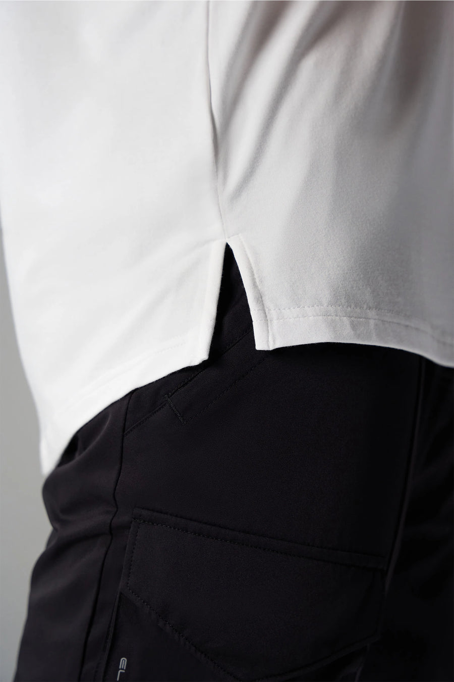 White Further Air-Flex Drop Arm Tank showing ultra-soft performance fabric and Take Life Further® chest logo detail by TLF Apparel – detail view