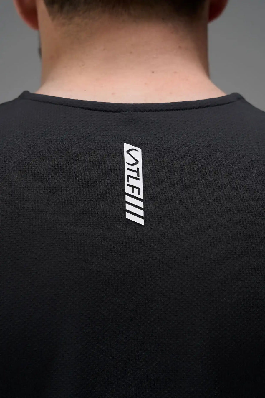 Black Men’s Micro Mesh Tank with a physique-enhancing fit, designed for gym training, HIIT workouts and running by TLF Apparel – back view 