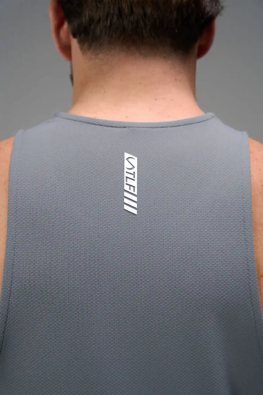 Gray Men’s Micro Mesh Tank with a physique-enhancing fit, designed for gym training, HIIT workouts and running by TLF Apparel – back view 