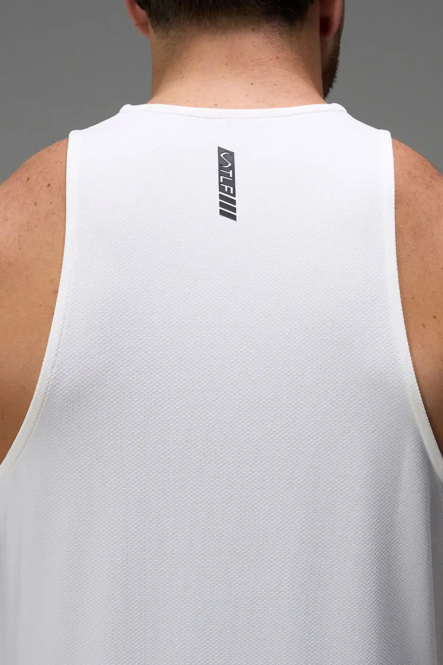 White Men’s Micro Mesh Tank with a physique-enhancing fit, designed for gym training, HIIT workouts and running by TLF Apparel – back view 