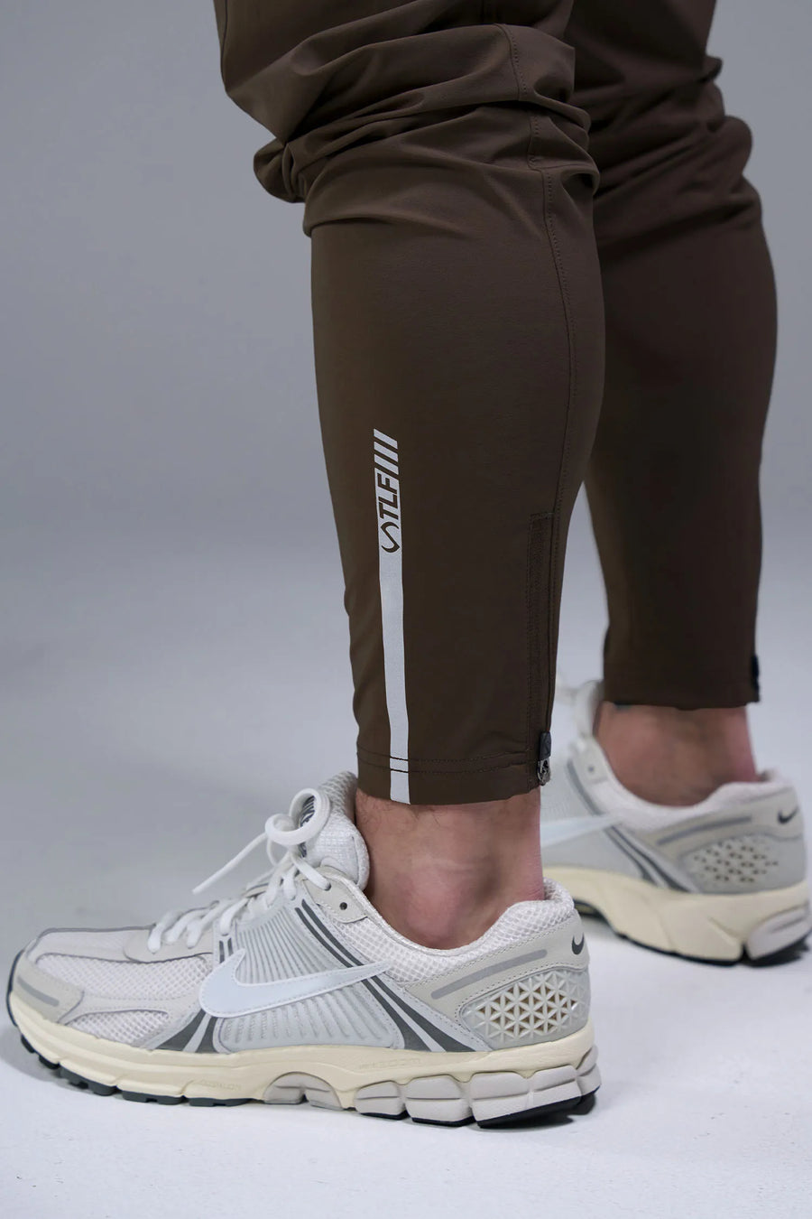 Back Detail View of Brown TLF Element Athletic Joggers 2.0, featuring side zipper pockets and side leg cargo pockets and reflective details 