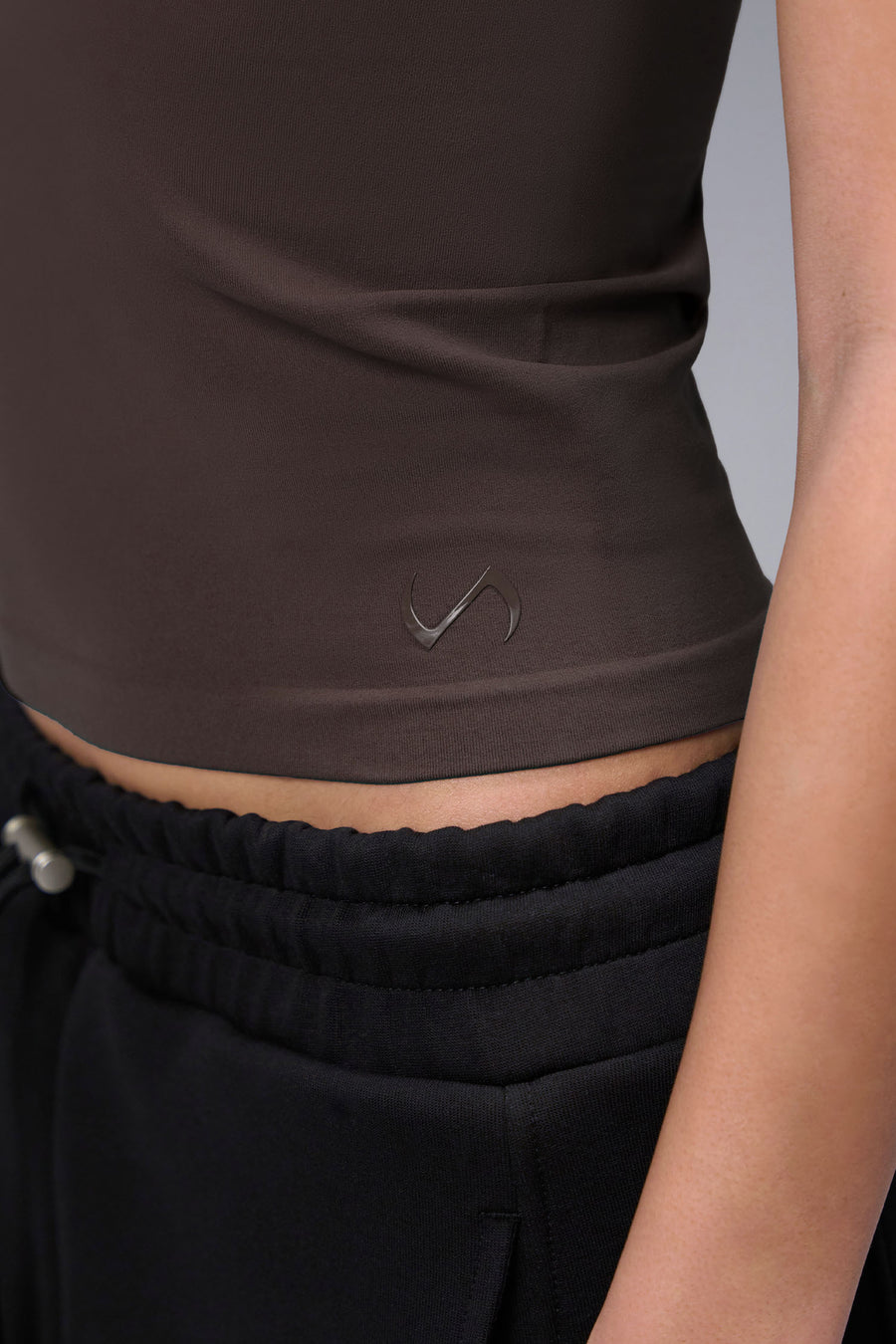 Women’s dark oak essential seamless short sleeve top with contouring fit for gym and lifestyle by TLF Apparel – detail logo view