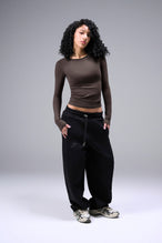 Women’s dark oak essential seamless long sleeve top with contouring fit for gym and lifestyle by TLF Apparel – full body hands in pocket front view