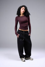 Women’s wine essential seamless long sleeve top with contouring fit for gym and lifestyle by TLF Apparel – full body hands in pocket front view
