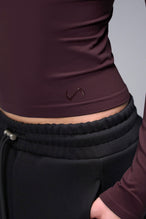 Women’s wine essential seamless long sleeve top with contouring fit for gym and lifestyle by TLF Apparel – detail logo view