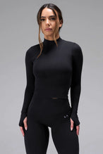 Front View of Black TLF Essential Seamless Mock Neck Long Sleeve, featuring thumbholes and mock neck for gym to street versatility