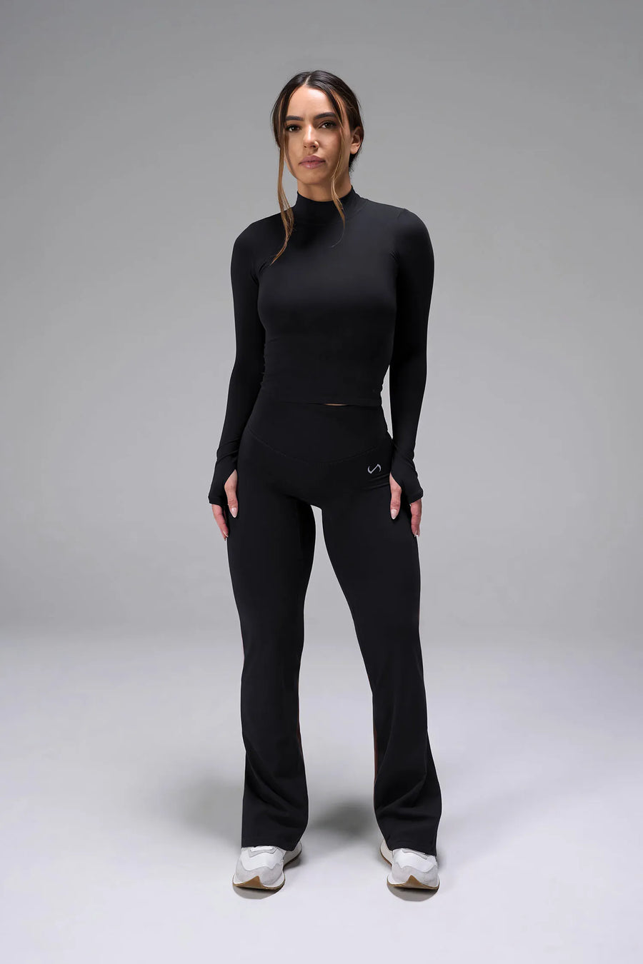 Front View of Black TLF Essential Seamless Mock Neck Long Sleeve, featuring thumbholes and mock neck for gym to street versatility