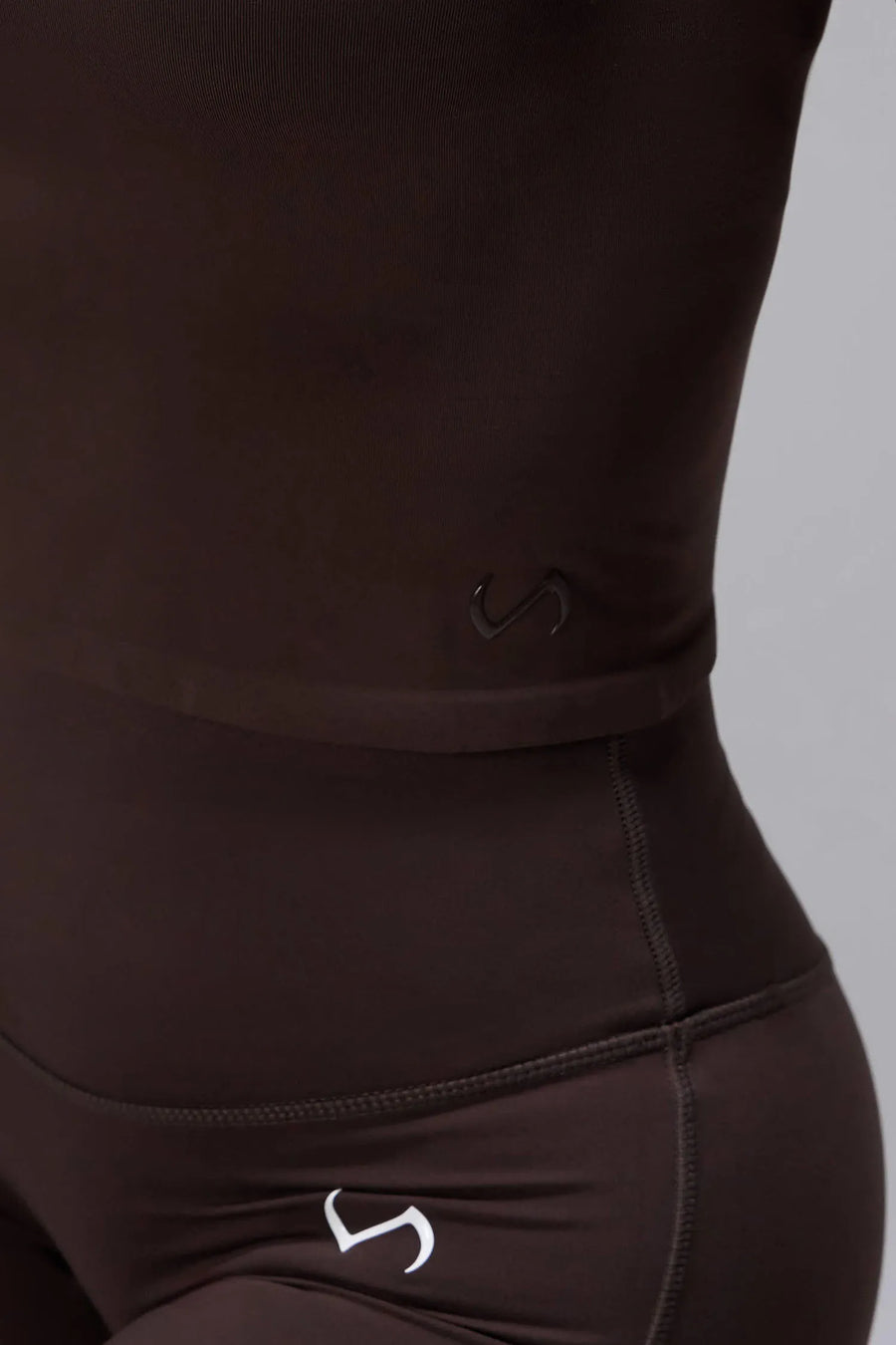 Detail Close View of Brown TLF Essential Seamless Mock Neck Long Sleeve, featuring thumbholes and mock neck for gym to street versatility