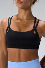 Black NeoCloud™ Strappy Sports Bra showing NeoCloud™ fabric, strappy back, and removable pads by TLF Apparel – front detail view