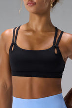 Black NeoCloud™ Strappy Sports Bra showing NeoCloud™ fabric, strappy back, and removable pads by TLF Apparel – front detail view