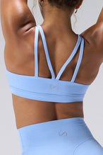 Blue NeoCloud™ Strappy Sports Bra showing NeoCloud™ fabric, strappy back, and removable pads by TLF Apparel – detail view