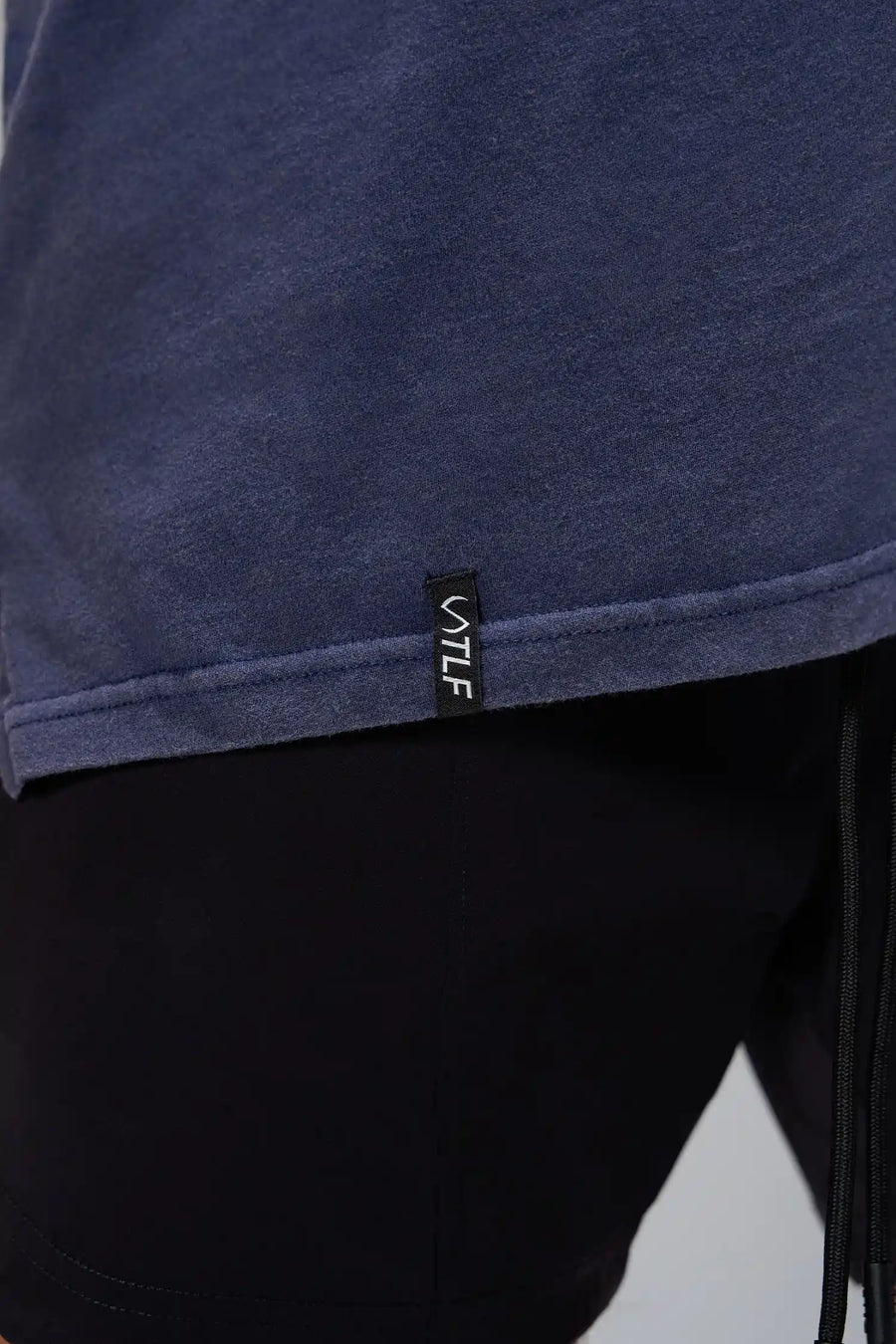 Navy Further Dura Cotton Short Sleeve Tee showing stone wash finish, woven hem clip label, and Dura Cotton DNA fabric by TLF Apparel – detail view 