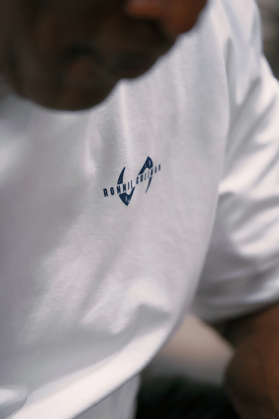 White Ronnie Coleman “Light weight baby” Tee showing Ronnie Coleman x TLF chest logo and ultra-soft Cotton Luxe DNA™ fabric by TLF Apparel – front detail view