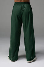Back View of Green TLF Baggy Track Pants (Men’s GTS Gym-To-Street Edition) featuring side pockets and reflective piping details with an oversized fit 
