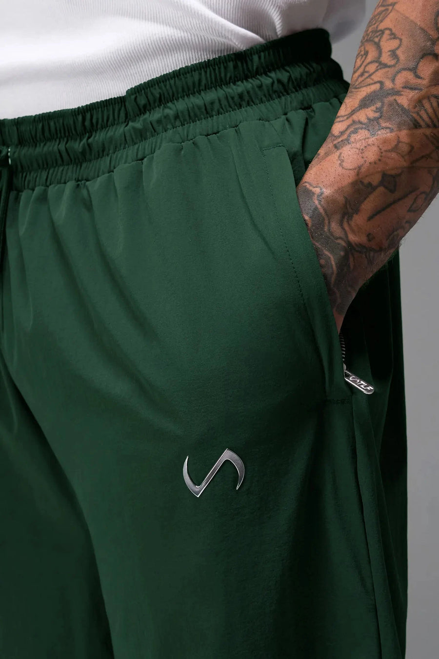 Detail View of Green TLF Baggy Track Pants (Men’s GTS Gym-To-Street Edition) featuring side pockets and reflective piping details with an oversized fit 