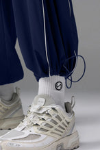 Detail Front View of Blue TLF Baggy Track Pants (Men’s GTS Gym-To-Street Edition) featuring side pockets and reflective piping details with an oversized fit 