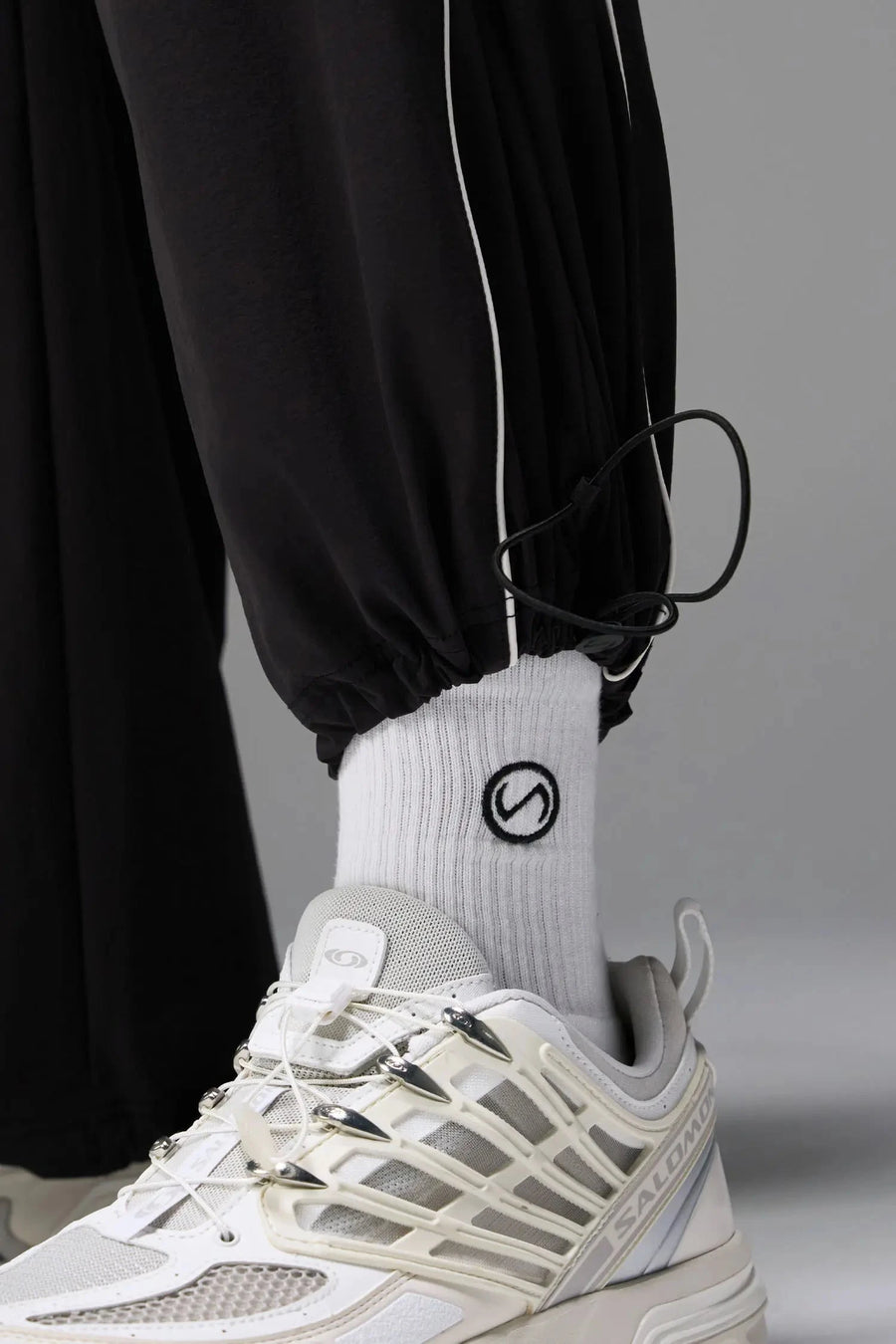 Detail Front View of Black TLF Baggy Track Pants (Men’s GTS Gym-To-Street Edition) featuring side pockets and reflective piping details with an oversized fit 