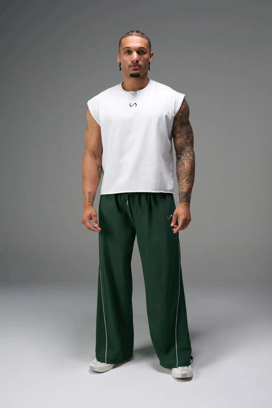Front View of Green TLF Baggy Track Pants (Men’s GTS Gym-To-Street Edition) featuring side pockets and reflective piping details with an oversized fit 
