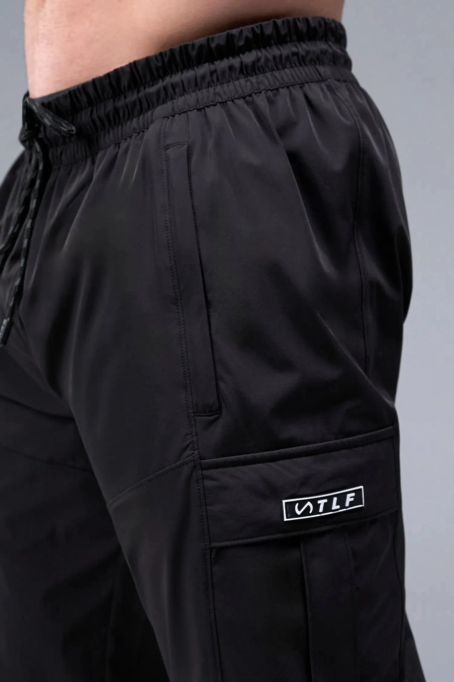 Detail Front View of Black TLF Element Athletic Joggers 2.0, featuring side zipper pockets and side leg cargo pockets and reflective details 